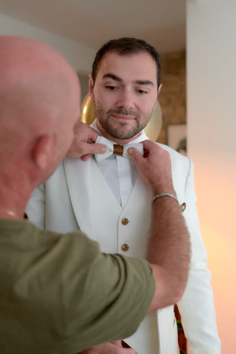 Le marié se fait ajuster le nœud papillon.