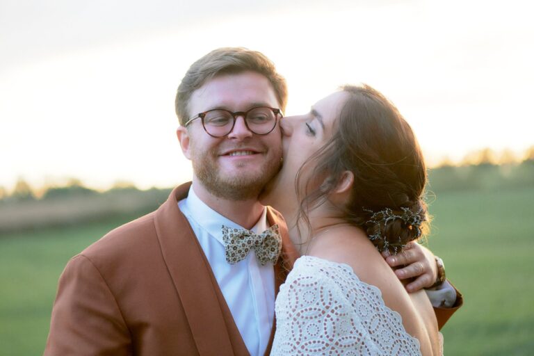 La mariée mord la joue de son mari lors d'une séance couple