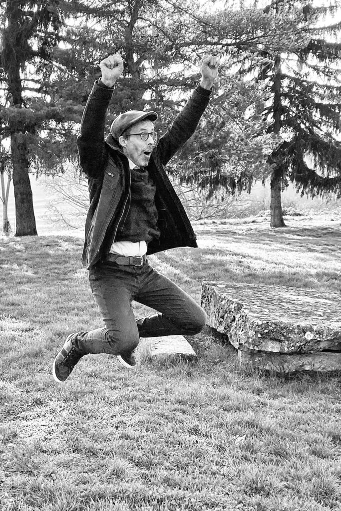 Portrait en Noir et Blanc de Marc SANCHEZ, Photographe à Nuits St Georges, entre Dijon et Beaune, entrain de sauter en l'air.