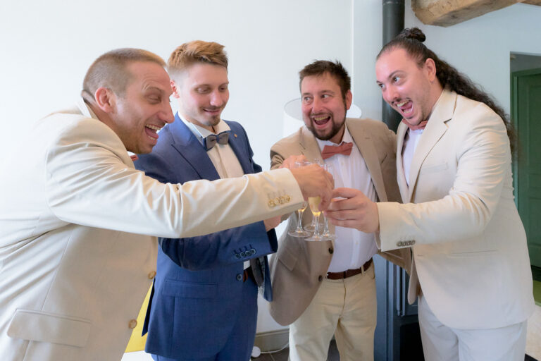 Témoins et marié en train de trinquer à la fin des préparatifs du mariés. Tous sont souriants et heureux.