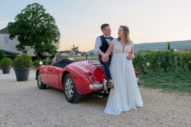 Couple de marié appuyés sur une belle voiture lors d'une séance couple.