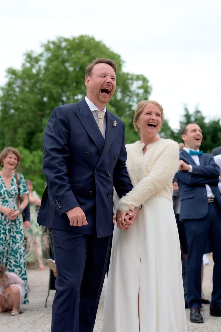Couple de mariés riant aux éclats lors d'un discours.