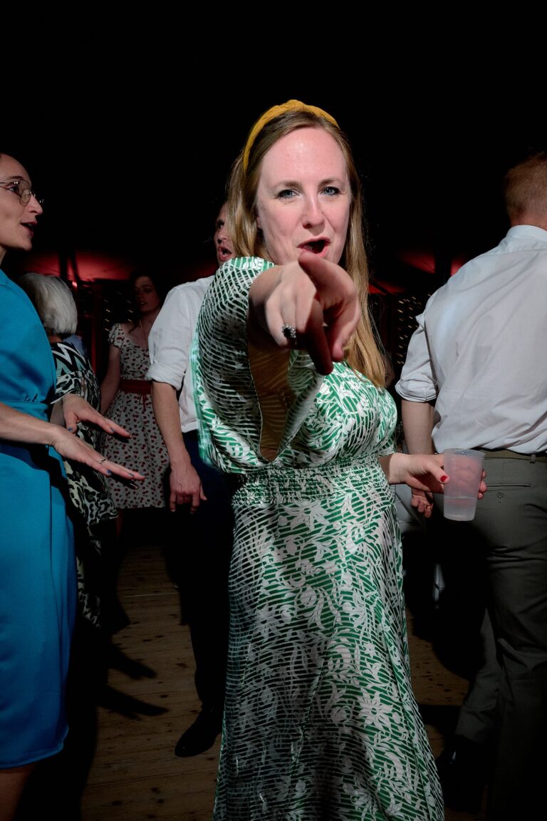 Une invité du mariage pointe son doigt en direction du photographe lors d'une danse.