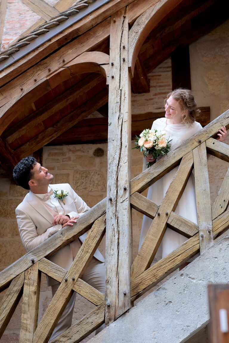 Couple de mariés dans un escalier, se regardant.