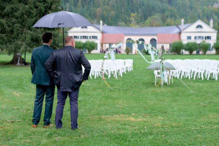 Wedding planer et marié sous un parapluie regardant le lieu vide de la cérémonie.