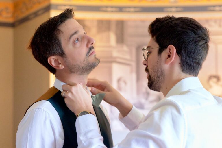 Marié se faisant ajuster le nœud papillon lors des préparatifs.