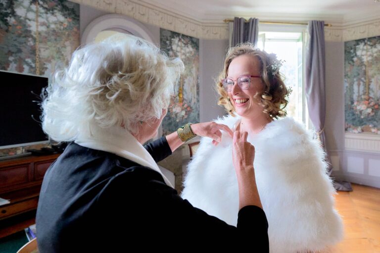La maman ajuste les derniers détails sur la mariée.